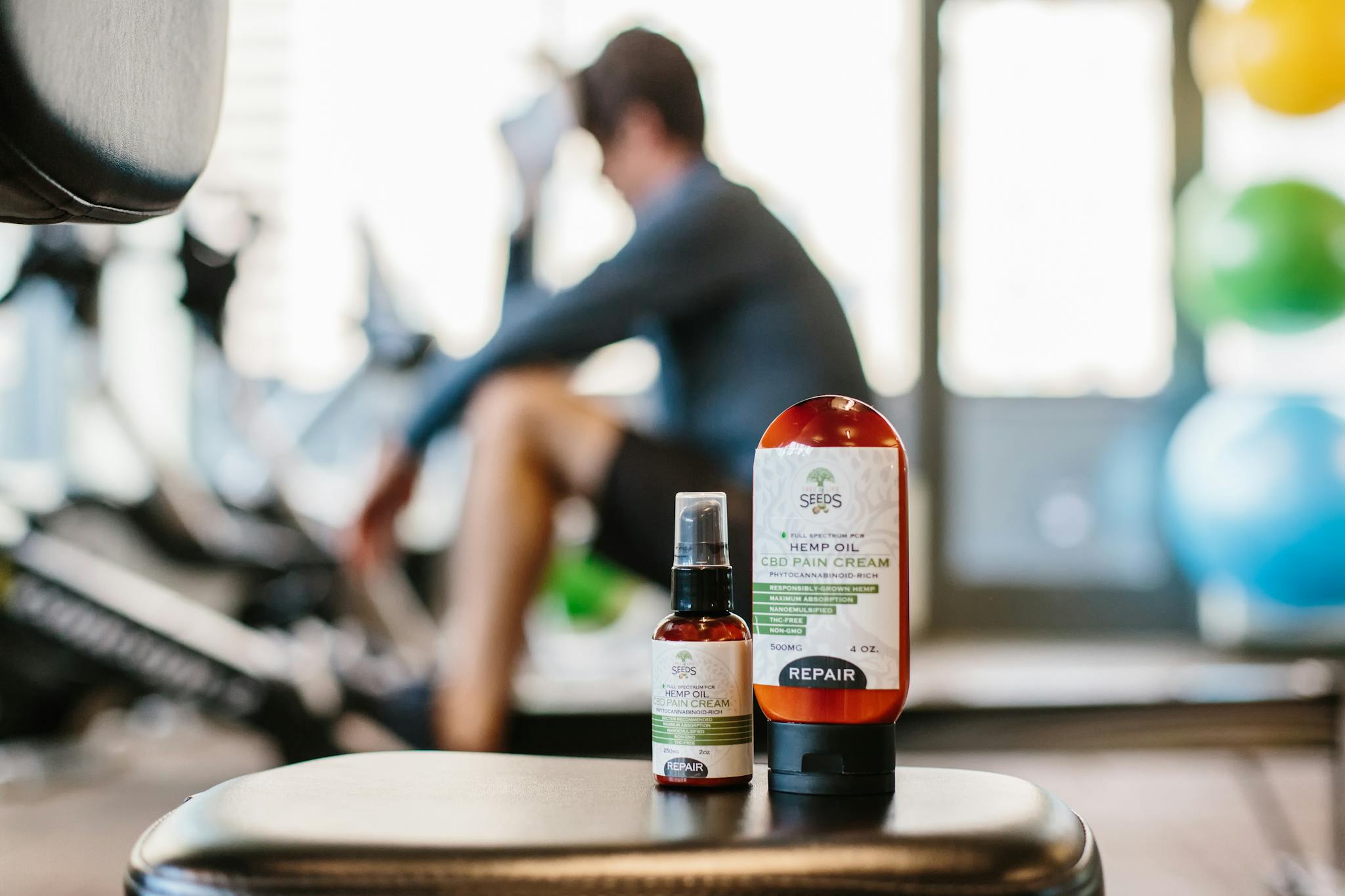 Close-up of hemp oil products in a gym focus on wellness and recovery.